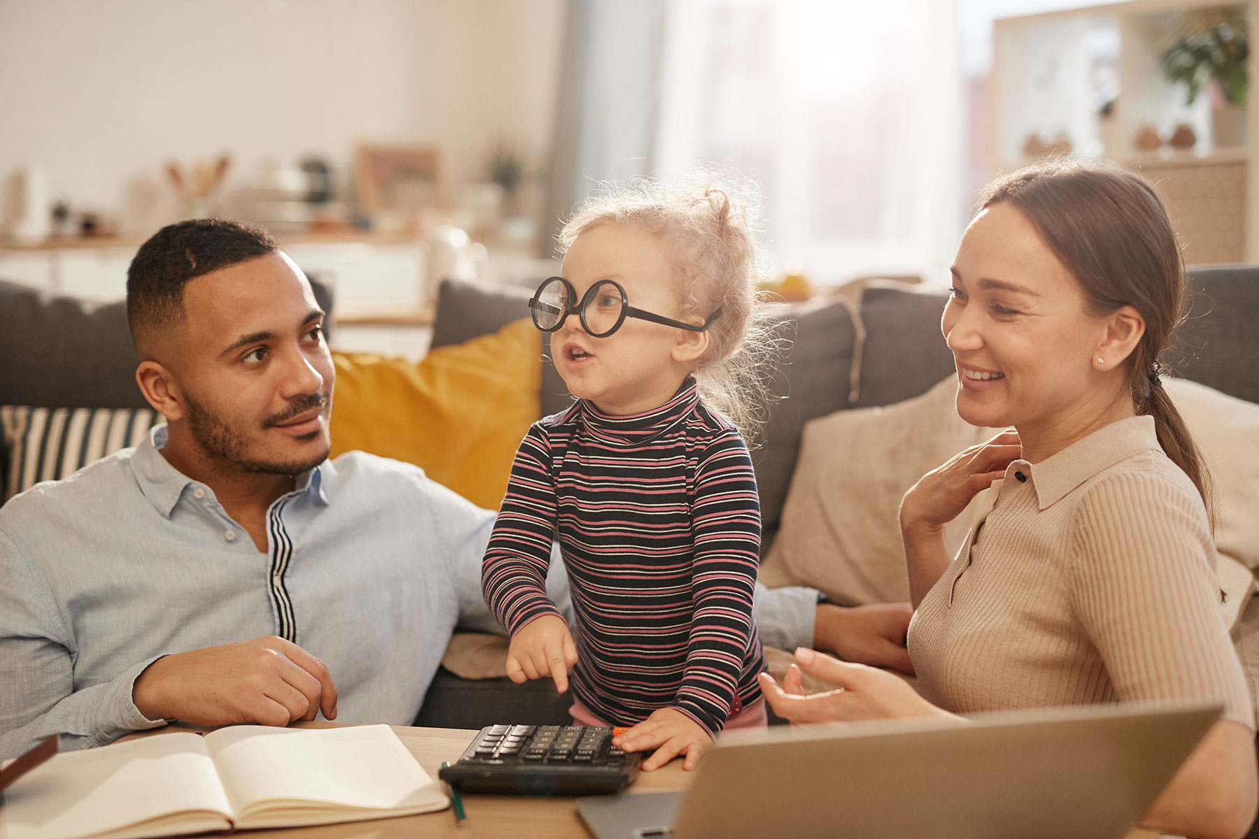 Young family with a child using a calculator wearing glasses