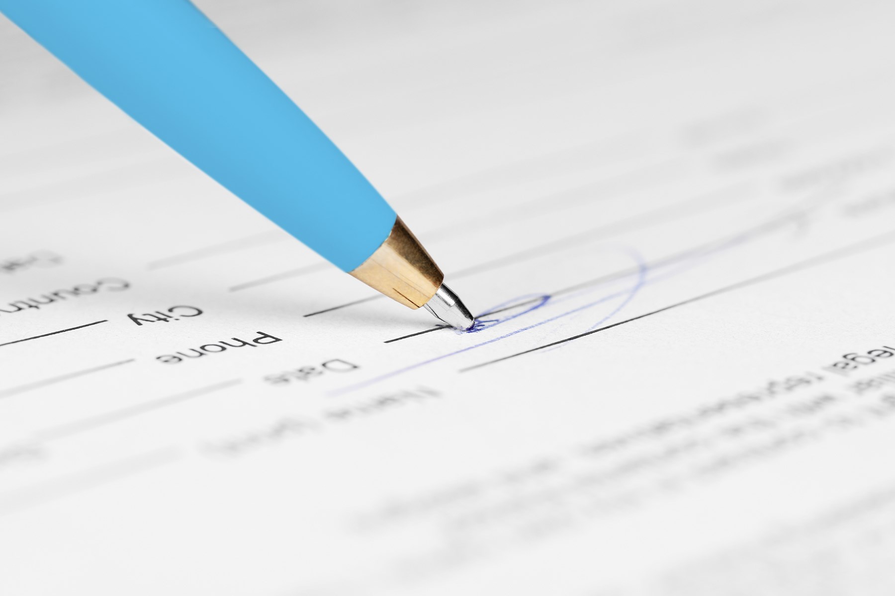Pen writing a signature on a form